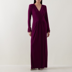 Model wearing purple long sleeve maxi dress with V-neckline, twist-knot waist detail and feather-trimmed cuffs
