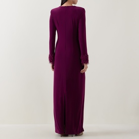 Model wearing purple long-sleeve maxi dress with feather-trim cuffs, back view showing column silhouette and rear split