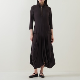 Model wearing Joseph Ribkoff Dress in Mocha, featuring zip-neck collar, three-quarter sleeves and draped drop-waist skirt, styled with black flats.