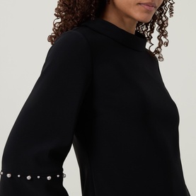 Model wearing Joseph Ribkoff Jewel Embellished Dress in black, close-up showing pearl-embellished cuffs on cropped sleeves
