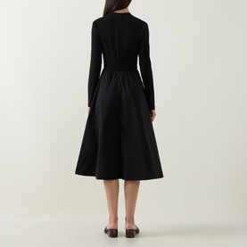 Model wearing Joseph Ribkoff Contrast Self-Tie Flared Dress in black, rear view showing midi-length flared skirt, long sleeves and back zip.