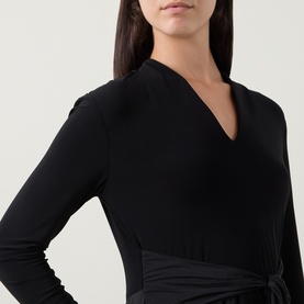 Model wearing Joseph Ribkoff Contrast Self-Tie Flared Dress in black, showing V-neckline, long sleeves, and self-tie waist detail.