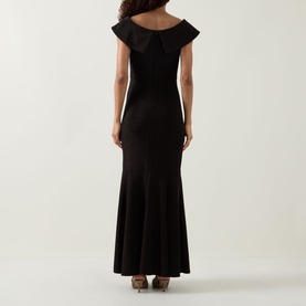 Model wearing Joseph Ribkoff bronze maxi dress, rear view, off-shoulder ruffle neckline, fitted bodice with fluted hem skirt.