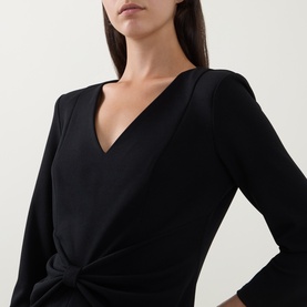 Model wearing Joseph Ribkoff Gathered Bow Pencil Dress in black, showing V-neckline and three-quarter length sleeves with gathered bow detail.