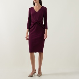 Model wearing Joseph Ribkoff Gathered Bow Pencil Dress in Elderberry, V-neckline, three-quarter sleeves, fitted midi length, styled with nude heels.