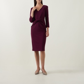 Model wearing Joseph Ribkoff Gathered Bow Pencil Dress in elderberry, V-neckline, three-quarter sleeves, midi length, styled with nude heels.