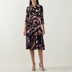 Model wearing Joseph Ribkoff Printed Wrap Dress in black/multi print, midi length, three-quarter sleeves and flared skirt, styled with nude heels.