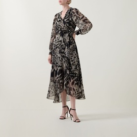 Model wearing Joseph Ribkoff grey multi animal print midi dress with long sleeves and wrap silhouette, styled with black strappy heels