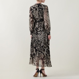 Model wearing Joseph Ribkoff grey multi animal print maxi dress, long sleeves, belted waist, with black strappy heels, rear view.