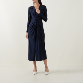 Model wearing Joseph Ribkoff Draped Cinched Dress in Midnight Blue, midi length, V-neck, twisted front detail and front slit, styled with white heels