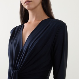 Model wearing Joseph Ribkoff Draped Cinched Dress in Midnight Blue, featuring deep V-neckline, twisted front detail and long sleeves.
