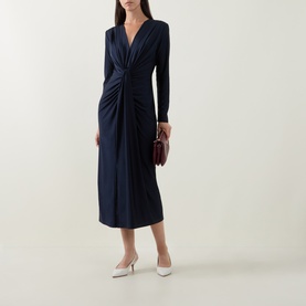 Model wearing Joseph Ribkoff Draped Cinched Dress in Midnight Blue, V-neck, twisted front, long sleeves, midi length; styled with white heels and