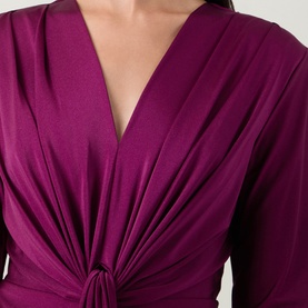 Model wearing Joseph Ribkoff Draped Cinched Dress in Berry Burst, showing V-neckline, twisted front detail and gathered draping on long sleeves.