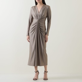 Model wearing Joseph Ribkoff Platinum Grey midi dress with V-neck, ruched front detail, and long sleeves, styled with black strappy heels.