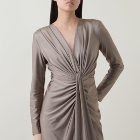 Model wearing Joseph Ribkoff Dress in Platinum Grey, long-sleeve wrap-style mini with ruched front and ring detail at waist.