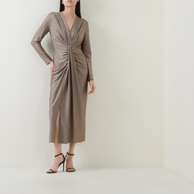 Model wearing Joseph Ribkoff Dress in Platinum Grey, long-sleeve V-neck midi with ruched front detail, styled with black strappy heels.