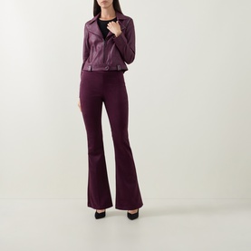Model wearing Joseph Ribkoff Studded Faux Leather Jacket in Elderberry with matching flared trousers and black heels.