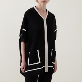 Model wearing Joseph Ribkoff black and birch hooded poncho jacket with contrast white trim detailing and patch pockets