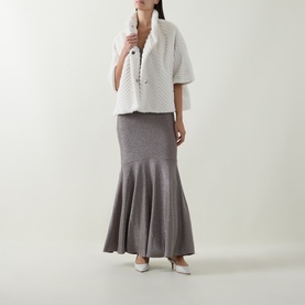 Model wearing Joseph Ribkoff Chevron Quilted Faux Fur Jacket in cream with funnel neck, styled with grey maxi skirt and white heels.