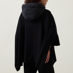 Model wearing Joseph Ribkoff black poncho jacket with quilted hood, rear view, oversized fit with side slits