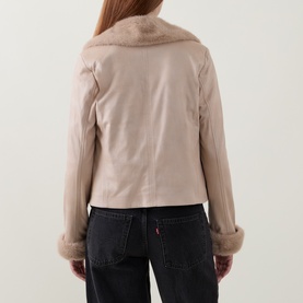 Model wearing Joseph Ribkoff Jacket in Soft Taupe, rear view, with faux fur collar and cuffs, paired with dark jeans.
