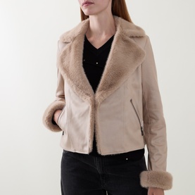 Model wearing Joseph Ribkoff Soft Taupe jacket with faux fur lapels and cuffs, styled with a black V-neck top and black trousers.