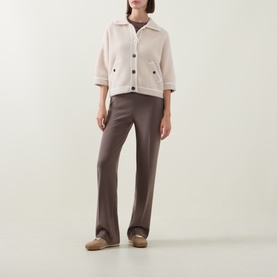 Model wearing Joseph Ribkoff Oatmeal/Winter White nylon jacket with dark button front, styled with brown trousers and beige shoes.