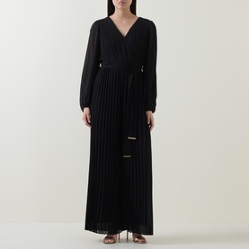 Model wearing Joseph Ribkoff black pleated wide-leg jumpsuit with wrap-style V-neckline, long sleeves, and tie waist.