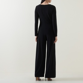 Model wearing Joseph Ribkoff black wide-leg jumpsuit, long sleeves, shown from the back with brown heels.