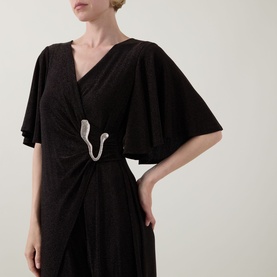 Model wearing Joseph Ribkoff bronze jumpsuit with flutter sleeves, wrap-style front, and silver serpent brooch detail.
