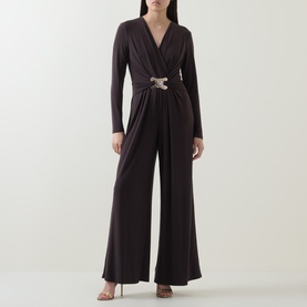 Model wearing Joseph Ribkoff Mocha Jumpsuit with wide-leg trousers, long sleeves, V-neck, and embellished buckle waist detail.