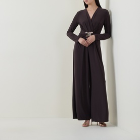 Model wearing Joseph Ribkoff Jumpsuit in Mocha, featuring V-neckline, long sleeves, wide-leg trousers and embellished belt detail.