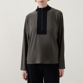 Model wearing Joseph Ribkoff Top in Avocado and Black with half-zip collar and contrast bib panel, styled with wide-leg black trousers