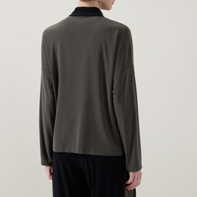 Model wearing Joseph Ribkoff Top in Avocado/Black, long-sleeve with contrast black collar, back view, paired with black trousers.