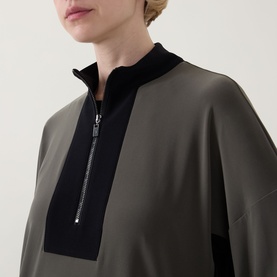 Model wearing Joseph Ribkoff Top in Avocado and Black with half-zip neckline, contrast ribbed collar and wide sleeves.