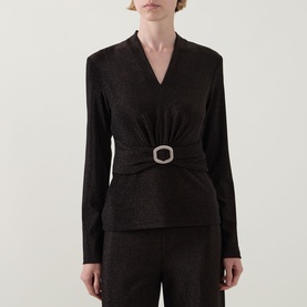 Model wearing Joseph Ribkoff bronze long-sleeve top with V-neck and crystal embellished buckle waist detail, styled with matching trousers.