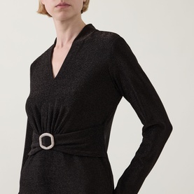 Model wearing Joseph Ribkoff bronze long-sleeve top with V-neckline, metallic shimmer fabric, and crystal embellished buckle detail at waist