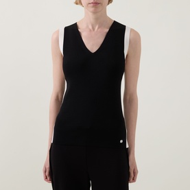 Model wearing Joseph Ribkoff Top in Black/Birch, sleeveless V-neck knit style with contrast white shoulder detail, paired with black trousers
