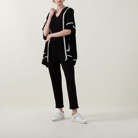 Model wearing Joseph Ribkoff black and birch open-front kimono-style top with white trim, styled with black trousers and white trainers.