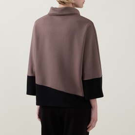 Model wearing Joseph Ribkoff Top in mink and black colourblock, featuring a cowl neck and wide three-quarter sleeves, rear view.