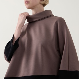 Model wearing Joseph Ribkoff Top in Mink and Black, featuring a wide cowl neck, oversized batwing silhouette and colour block panels.