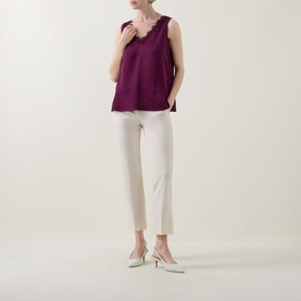 Model wearing Joseph Ribkoff Berry Burst sleeveless top with lace trim neckline, styled with cream tapered trousers and slingback heels.