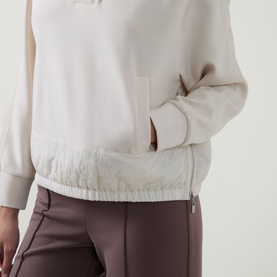 Model wearing Joseph Ribkoff Textured-Trim Sweatshirt in Birch with contrast elasticated hem trim, styled with dark mauve trousers.