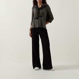 Model wearing Joseph Ribkoff Contrast Neckline Top in Avocado/Black with open collar and tie neck detail, styled with wide-leg black trousers