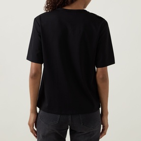 Model wearing Joseph Ribkoff black short-sleeve top, rear view, styled with dark grey trousers.