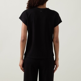 Model wearing Joseph Ribkoff black short-sleeve top, rear view, styled with black wide-leg trousers.