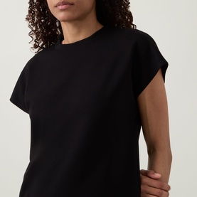 Model wearing Joseph Ribkoff black sleeveless top with cap sleeves and crew neckline, close-up front detail view.