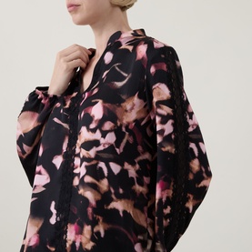Model wearing Joseph Ribkoff Top in black and pink abstract print, relaxed fit with batwing sleeves and V-neckline detail.