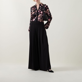 Model wearing Joseph Ribkoff black and pink floral print top with wide-leg black trousers and black pointed-toe flats.