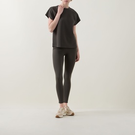 Model wearing Joseph Ribkoff Avocado top with matching leggings and beige chunky trainers.